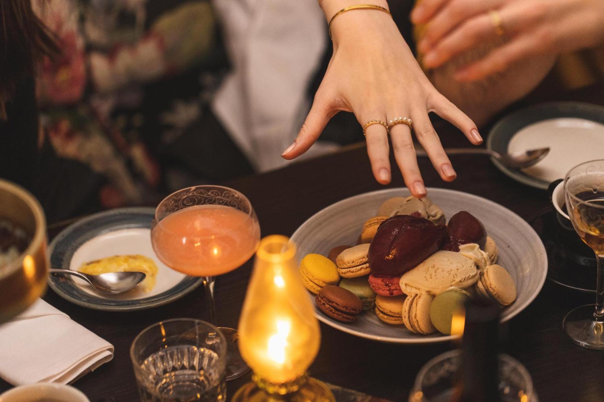 Hotel Pigalle Gotemburgo Exterior foto A woman's hand reaches for a plate of macarons